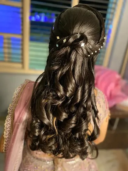 A modern half-up style with a braided crown, diamond-shaped pins, and beautiful spiral curls.