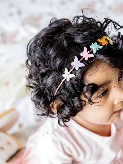 This little one's gorgeous curls and happy smile are just too adorable. I make sure to capture all the little details, like the cute butterfly clips in her hair.
