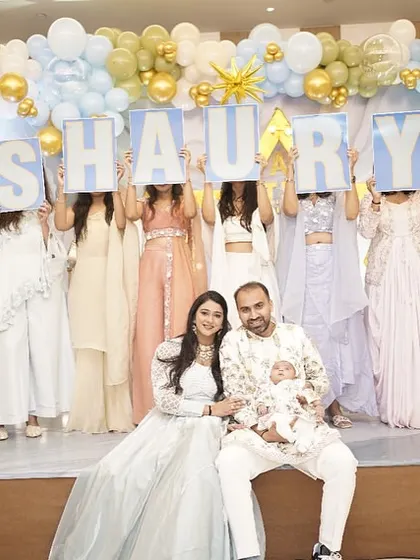 The big reveal! Family members hold up letters to spell out the baby's name, 'SHAURYA,' in front of the happy parents.