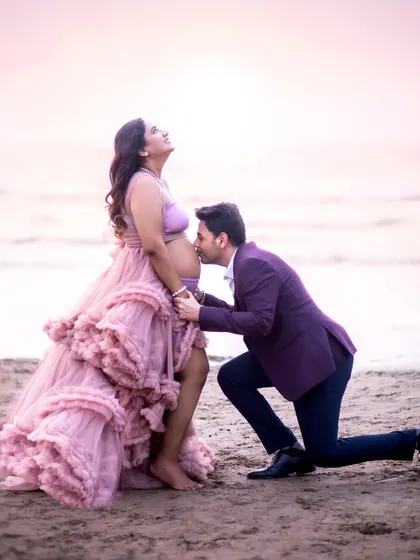 A sweet kiss for the baby bump. This is a classic and heartwarming pose that every expecting couple treasures.