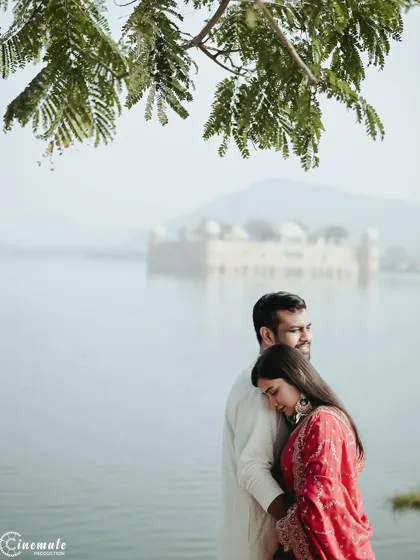 A tender moment captured at Jal Mahal, with the woman resting her head on her partner's shoulder. The soft, hazy background of the water palace adds a touch of magic to this romantic portrait.