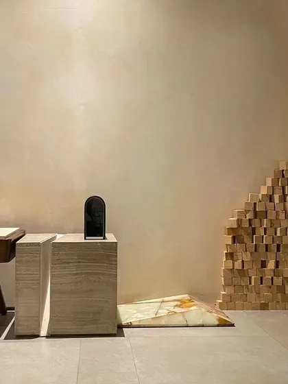 This detail shot from our studio highlights the dialogue between art and architecture. The minimalist space acts as a gallery for sculptural furniture and unique material applications, like the onyx marble accent on the floor.