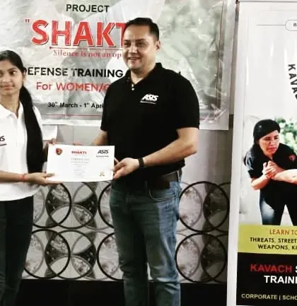 A participant from Project "Shakti" receiving her certificate. This is a moment of pride and a symbol of her commitment to her own safety.