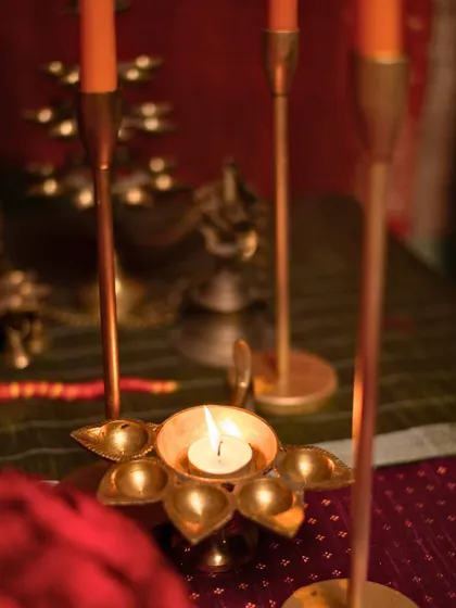 A traditional brass 'diya' provides a moment of serene light amidst the vibrant decor.