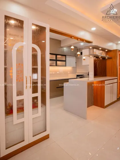 A serene and elegant pooja unit with frosted glass doors featuring a modern arch design. The interior is well-lit, creating a divine and peaceful corner in the home.