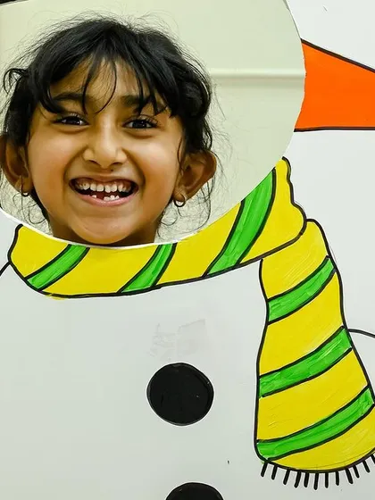 A big, happy smile from a child enjoying the snowman photo booth. Capturing these happy memories is so important.