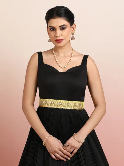 A close-up of the black gown's bodice, featuring a sweetheart neckline and a beautifully embellished golden belt.
