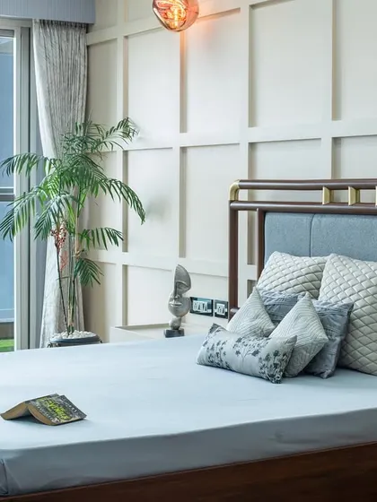 The bed, with its unique wooden frame and brass accents, is set against a backdrop of classic wall paneling. The design feels both modern and timeless, a signature of my work.