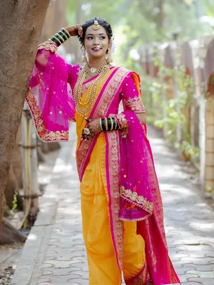 A full-length shot showcasing the complete Maharashtrian bridal attire. The draping of the Nauvari saree and the elegant hairstyle come together for a truly regal look.