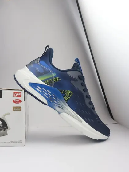 The raw, behind the scenes shot of a blue Fila sneaker propped up on a box before being edited into the final composite.