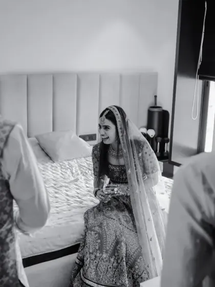 A candid black and white moment of the bride in her room before the ceremony, surrounded by family.