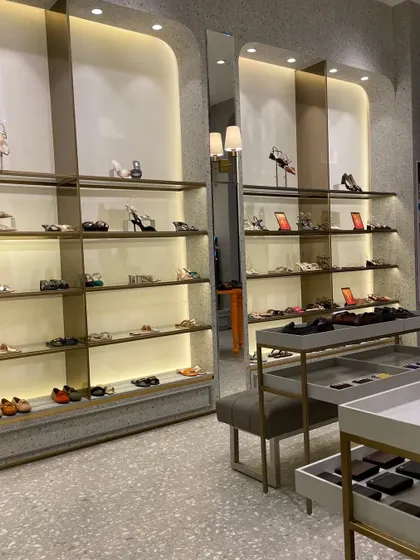 The women's shoe section, featuring curved, recessed shelving units that create an elegant and boutique-like feel.