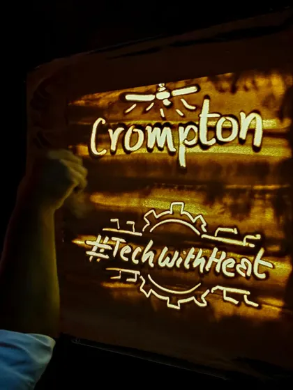 A close-up of the sand art created for Crompton, featuring their logo and campaign hashtag. I ensure that key branding elements are clearly and artistically represented in the final visuals.