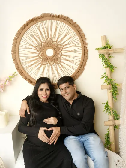 A wider shot of a couple's portrait in the boho corner, showing more of the relaxed, natural-themed decor.