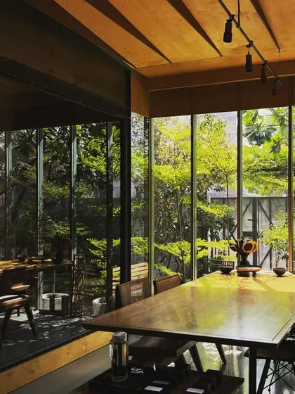 This is our studio, bathed in morning sun. We designed our own workspace to be a living example of our principles, where the interplay of light, wood, and surrounding greenery creates a calm and inspiring environment for creativity.