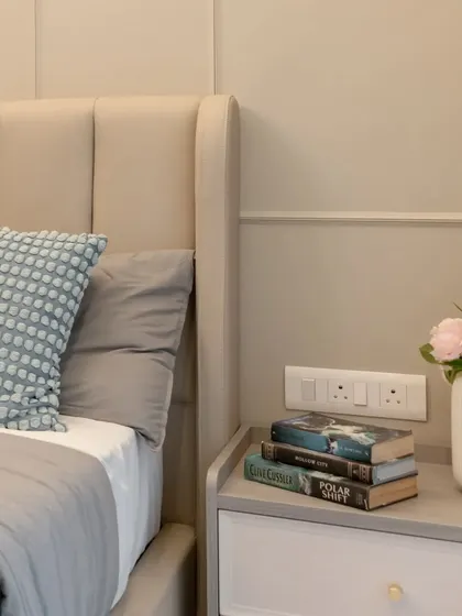 A close-up of the styling on the bedside table, with a stack of books and a vase of flowers adding a personal and cozy touch.