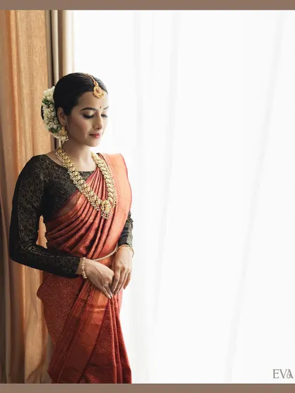 A full-length portrait showcasing the entire look. The makeup, hair, and saree are all styled to create an elegant and cohesive image for the brand.