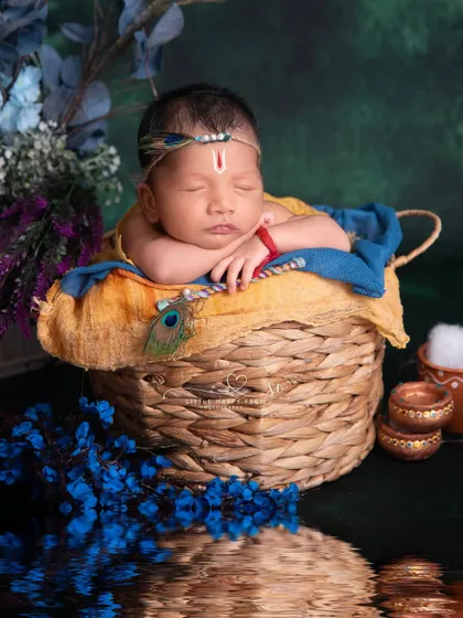 This portrait of a sleeping Kanha in a basket by the water is so serene. The reflection adds a beautiful, artistic touch, making the image feel like a timeless painting.