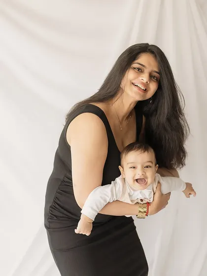 Pure, uncontainable joy. A mother holds her laughing baby, a perfect example of the happy, energetic moments we capture in a milestone shoot.