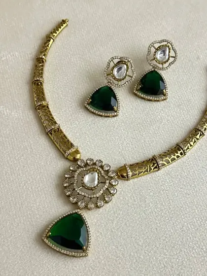 A unique hasli-style necklace with a modern design, featuring green and white uncut stones. A great rental for someone looking for something different.