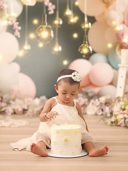 The quiet moment of curiosity just before the smashing begins. This elegant setup with soft pinks and fairy lights is perfect for a whimsical first birthday theme.