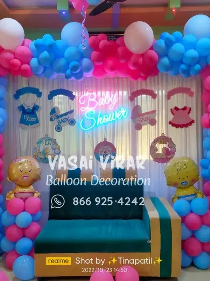 I can transform any corner of your home into a beautiful photo booth. Here, I framed a sofa with a dense pink and blue balloon arch and hung cute baby-themed cutouts from the top for a fun baby shower setup.