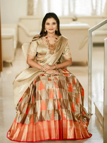 A seated portrait of the client, showcasing the rich fabric and the comfortable fit of her custom half saree.