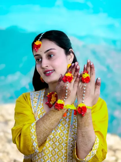 A happy bride-to-be, adorned in yellow and floral jewelry for her pre-wedding ceremony.