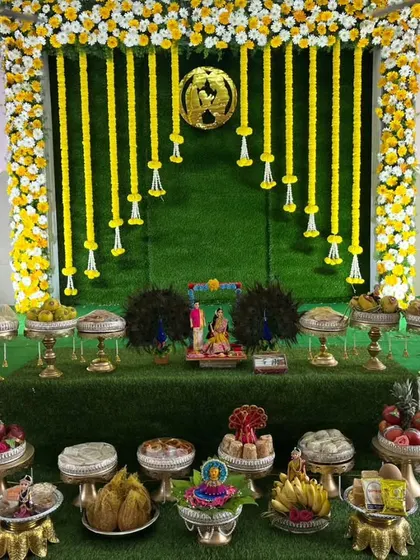 This is a complete Seemantha decor package. It includes a beautiful floral backdrop with hanging yellow flower strings and a full display of our intricately decorated traditional plates (aarathi thatte).
