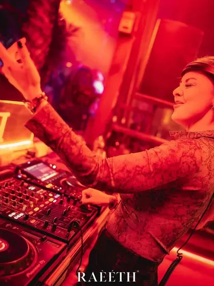 Throwing up a sign of approval to the crowd at Raeeth. The red lighting and intense atmosphere are typical of my club nights.