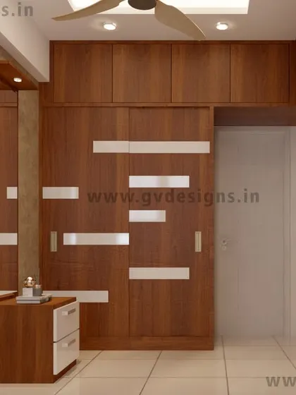 This sliding wardrobe combines a warm wooden finish with frosty white patch-look designs on the door for a modern, graphic effect. The design is paired with a matching dressing table, creating a cohesive and functional bedroom set.