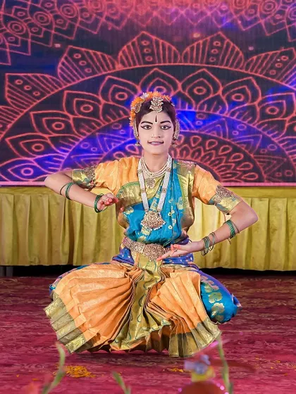 A young Bharatnatyam dancer in a traditional pose on stage. We work to capture the grace and discipline of young performers during cultural events.