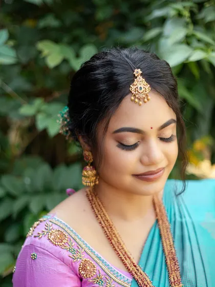 A close-up of Sugirtha's engagement makeup with her eyes closed. The soft, shimmery eyeshadow and defined brows create a polished and elegant look.