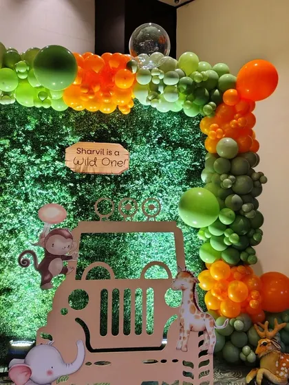 A close-up of our jungle jeep photo-op. This setup for "Sharvil is a Wild One" includes a greenery wall and a fun balloon frame, making it the perfect spot for guests to take memorable pictures.