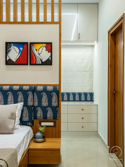This shot shows the clever integration of a seating nook with storage drawers into the bedroom's entryway. The paisley fabric ties in with the headboard, creating a cohesive design story.