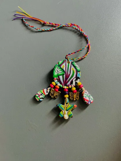 This is a one-of-a-kind Lumba I made for the Rakhi season. It's crafted from polymer clay, wooden beads, and features a real pearl at the bottom.