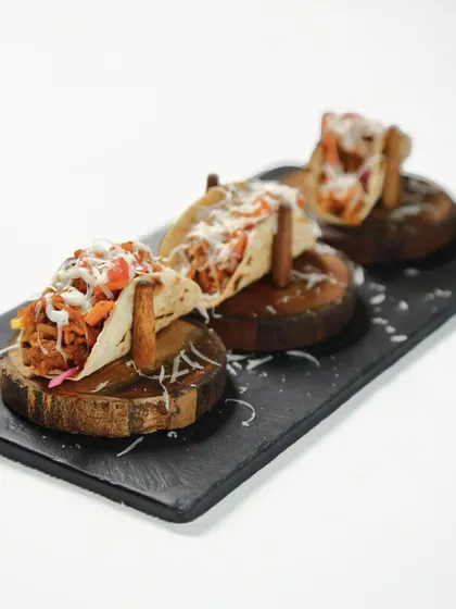 Taco, but make it Indian. We serve pulled jackfruit in a soft phulka shell, drizzled with lime cream and a pop of salsa for a dish that is bold, bright, and unmistakably inventive.