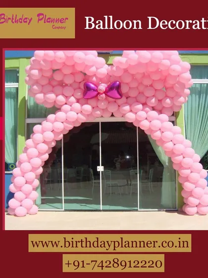 A fun and playful entrance created with a large balloon arch shaped like a giant pink bow. This is a perfect way to welcome guests to a birthday party or baby shower.
