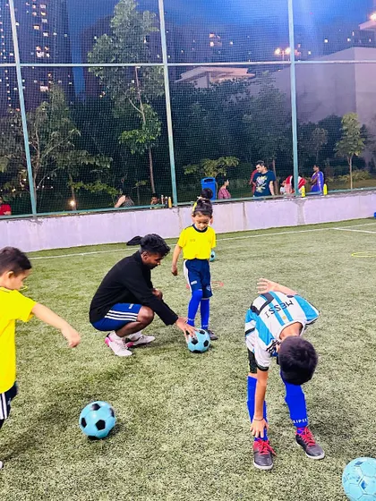 A coach corrects a player's stance. Attention to the small details makes a big difference in a player's development.