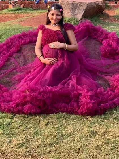 Feel the glow of pregnancy in this soft and flowy magenta ruffle gown. The design spreads out beautifully on the ground for stunning seated portraits.