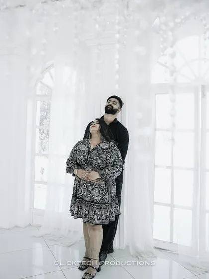 A romantic embrace in a bright, all-white room with sheer curtains, creating a dreamy and ethereal feel.