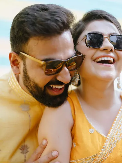 A candid close-up of the couple sharing a laugh, their faces glowing with happiness.