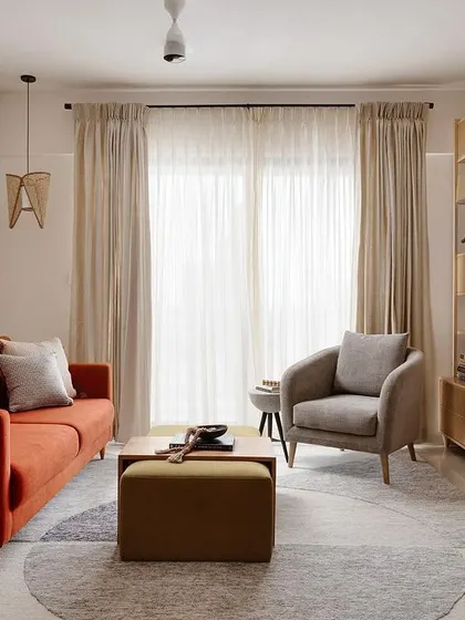 Another view of the 'Soulful Sanctuary' living room, showing how the white brick wall, sheer curtains, and light wood tones work together to create a bright, airy, and relaxing atmosphere.
