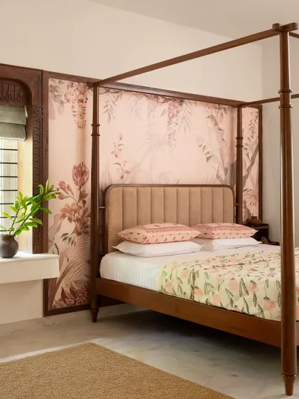 This master suite in 'Project Varnika' is defined by a stunning four-poster bed and custom floral wallpaper. I used soothing pastels and rich wood to create a romantic and timeless retreat.