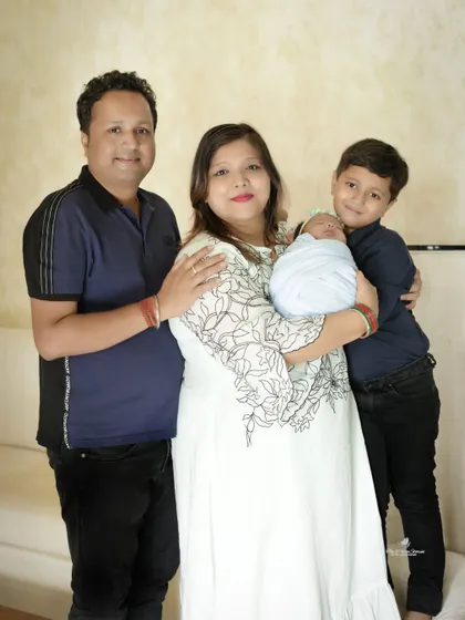 Another lovely family pose, showcasing the proud parents and the excited older brother with their newborn baby.