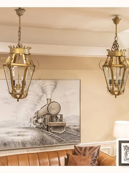 This pair of luxurious pendant lamps exudes sophistication. Their lantern-like design with intricate metalwork and glass panels makes them a stunning focal point for a living room or entryway.