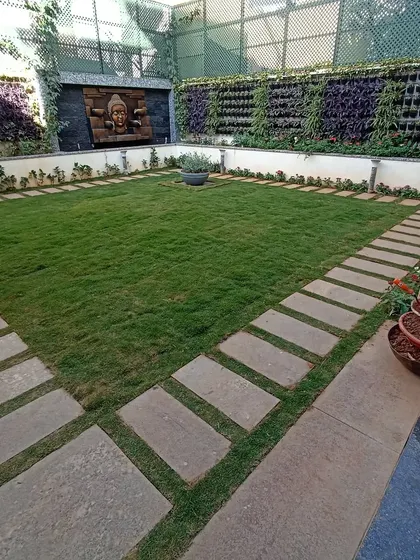 My work extends to complete landscape design. For this courtyard, I installed a neat lawn bordered by stone pavers and flanked by two large living vertical gardens, creating a serene and structured outdoor sanctuary centered around a water feature.