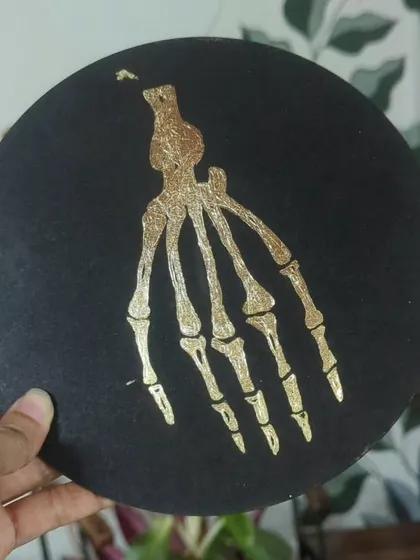 A skeletal hand design created with gold foil, showing the fine details you can achieve with this technique.