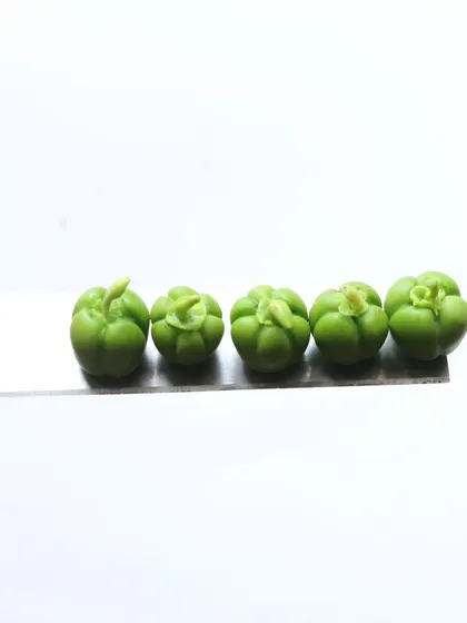 A close-up of five miniature capsicums, showing their realistic shape and color.