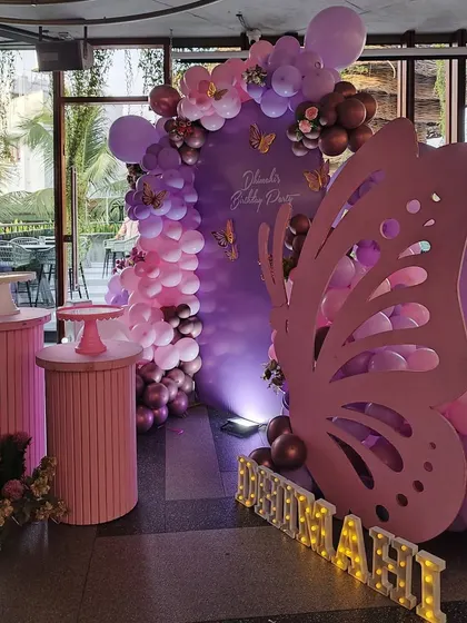 A wider view of the elegant butterfly party decoration, showing the full arrangement with plinths and marquee letters.